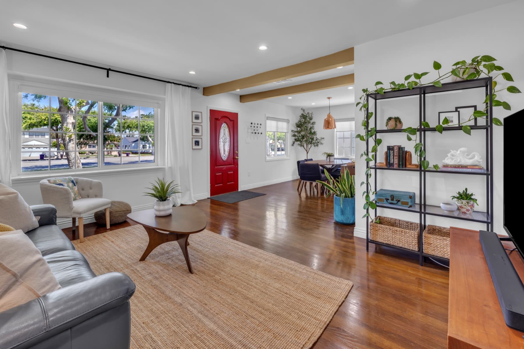 Open living area with wood flooring and a red front door